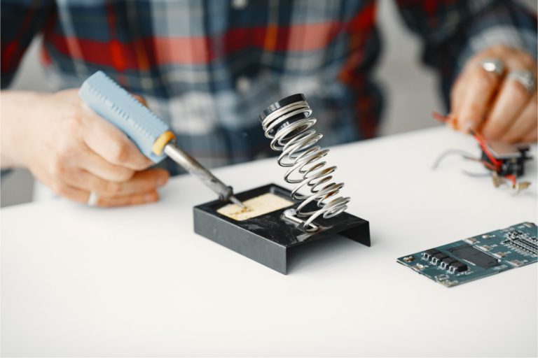 senior-man-with-equipment-for-soldering-working-at-home